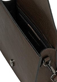 Brązowa skórzana kopertówka o teksturowanej powierzchni, z zamkiem błyskawicznym i metalowym zapięciem. Posiada odczepianą rączkę i czarne akcenty.