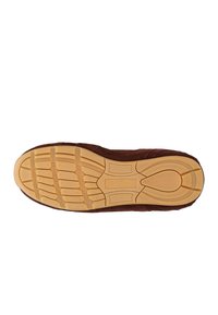 Suola della scarpa con impugnatura in gomma beige, caratterizzata da un motivo di battistrada segmentato e tomaia in suede marrone, mostrata dal basso su uno sfondo bianco.