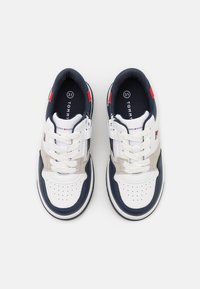 Witte en marineblauwe sneakers met een grijze accent. Kenmerken zijn onder andere veters en een rits aan de zijkant. Gelaagd zool met geperforeerde sections voor ademend vermogen.