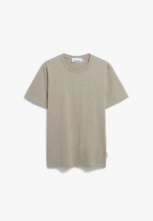 Helle beige Baumwoll-T-Shirt mit kurzen Ärmeln, Rundhalsausschnitt und einem schlichten Design. Das Etikett an der unteren Seite zeigt den Markennamen.