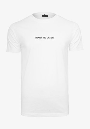 Balts kokvilnas T-krekls ar īsām piedurknēm, ar melniem burtiem "PATEICIES VĒLĀK", kas drukāti centrā biezā, sans-serif fontā.