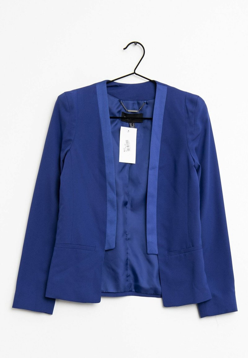 Blazer bleu pour femme avec devant ouvert suspendu sur un cintre noir sur fond blanc, montrant une doublure intérieure lisse et une étiquette de prix attachée.