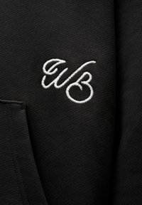 Czarna bluza z haftowanym białym logo "wb", o miękkiej fakturze i z kieszenią typu kangur.