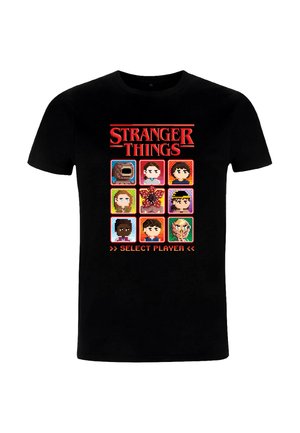 T-shirt noir avec un design en pixel art comprenant neuf portraits de personnages de "Stranger Things", rehaussé de couleurs vives et d'une bannière de texte.