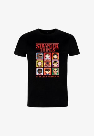 Zwart T-shirt met een pixelart-ontwerp met negen portretten van personages uit "Stranger Things", geaccentueerd met levendige kleuren en een tekstbanner.