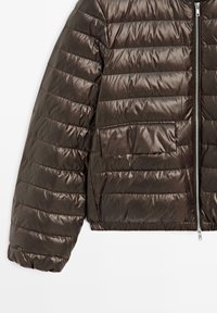 Veste matelassée marron avec une texture douce et brillante. Comprend des coutures horizontales, une fermeture éclair frontale, et un ourlet et des poignets élastiqués.
