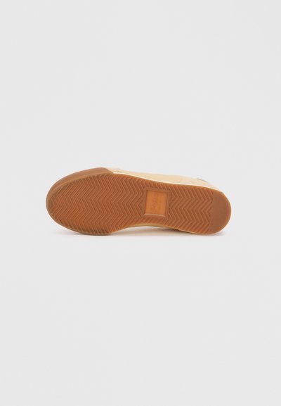 Suola della scarpa con un motivo a spina di pesce, materiale in gomma semi-traslucido di colore marrone chiaro, con un logo rettangolare integrato.