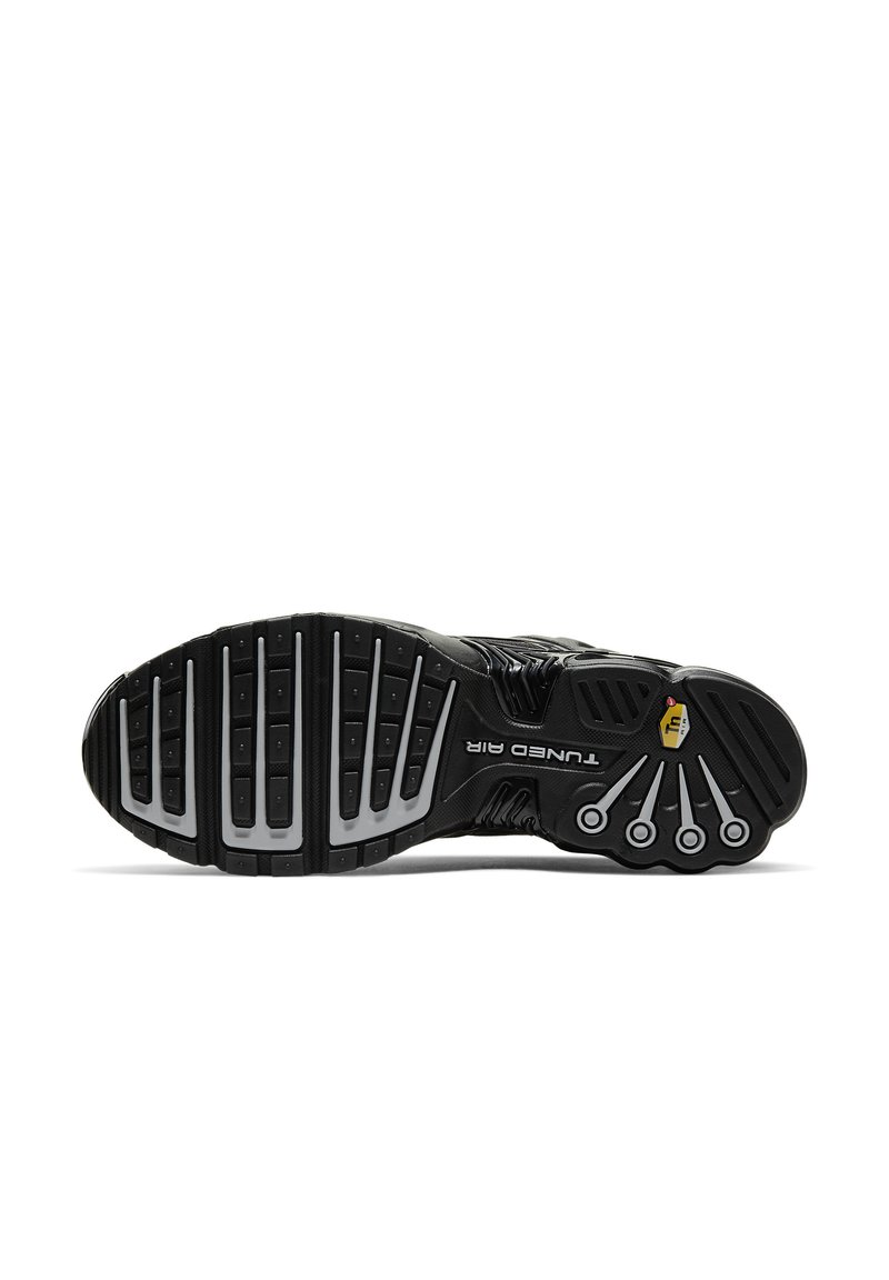 Suela de sneaker negra con banda de goma, que presenta un diseño acolchado, ventilaciones visibles y patrones texturizados elevados. Accentuada con detalles del logo.