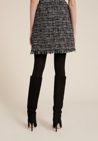 Svarta knähöga klackstövlar i mjukt mocka. Snygg design med spetsig tå och åtsittande form, kompletterad med stilettklack.