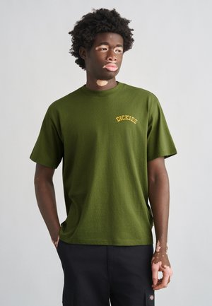 Bombažna majica v olive zeleni barvi z okroglim izrezom in kratkimi rokavi, z majhnim rumenim logotipom "DICKIES" na levi prsni strani.