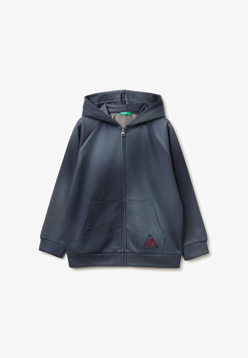 Sudadera con cremallera de color azul marino, confeccionada en un tejido suave, que presenta una gran capucha, dos bolsillos frontales y un parche con un logo en forma de triángulo en el bolsillo izquierdo.