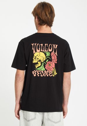 Black cotton T-shirt featuring a colorful graphic design on the back, including a skull, flowers, and the text "VOLCOM STONE."