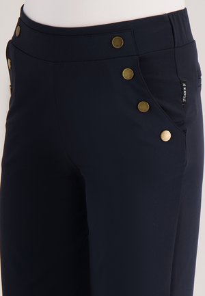 Marineblauwe broek met een aansluitend ontwerp, voorzien van vijf gouden knopen langs de taille en zijzakken. Gemaakt van een gladde, rekbare stof.