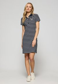 Abito polo a righe blu navy e bianche con maniche corte, colletto e logo ricamato sul petto. Tessuto in cotone con una forma aderente.