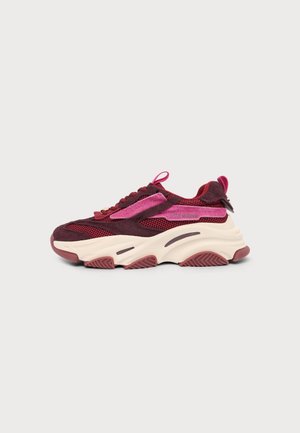 Baskets épaisses en mesh bordeaux et rose et en daim, semelle blanche épaisse avec relief, vue latérale sur fond clair uni.