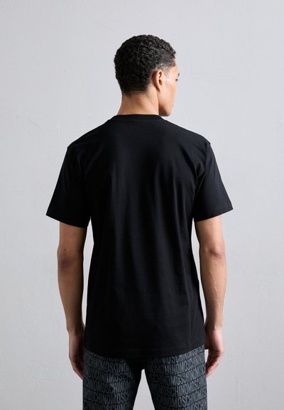 T-shirt noir en coton à manches courtes avec un col rond, présentant une texture lisse et une coupe décontractée. La vue arrière montre un design épuré.