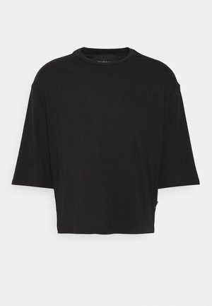 Sort oversized t-shirt med rund halsudskæring, korte ærmer og glat tekstur. Har en lige kant og et minimalistisk design.