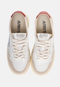 Sneakers bianchi in pelle con accenti in suede grigio e dettagli perforati; presentano una suola intermedia beige e un tab sul tallone rosso. Lacci nello stesso colore.