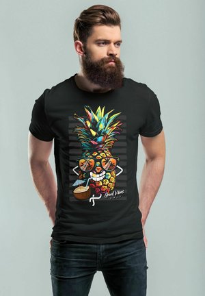 Black t-shirt featuring a colorful pineapple graphic wearing sunglasses, with a straw drink, and the text "Good Vibes Only" below.