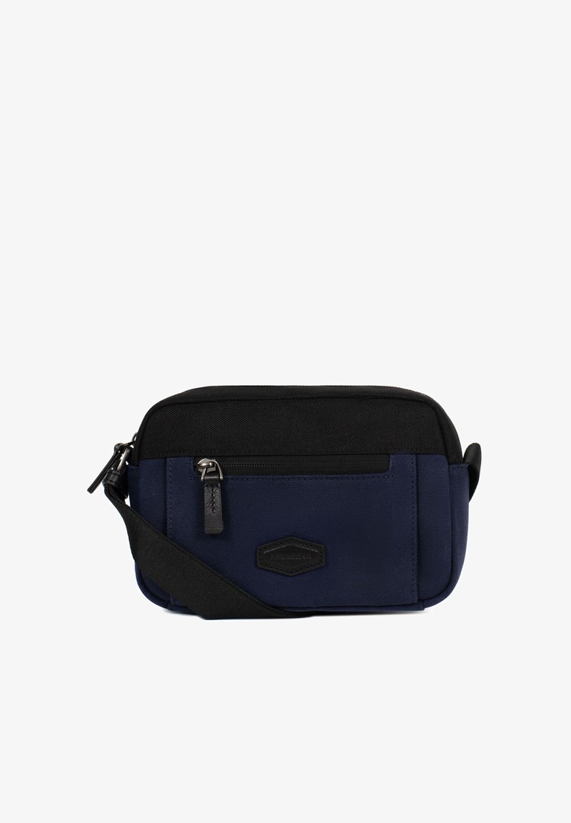 Kleine marineblauwe en zwarte crossbodytas met voorzak met rits en verstelbare stoffen riem, weergegeven tegen een witte achtergrond.