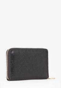 Cartera de cuero negra con superficie texturizada, con una cremallera dorada y un borde liso. Forma rectangular compacta, diseño minimalista.