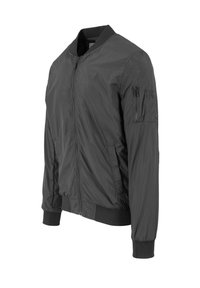 Black bomber jacket made of lightweight, smooth fabric. Features a zip closure, ribbed cuffs, and a zippered pocket on the left sleeve.