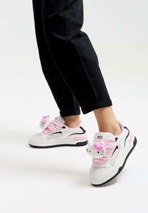 Białe sneakersy z różowymi akcentami, z aplikacją Hello Kitty, teksturowaną siateczką, grubą czarną podeszwą i różowymi sznurówkami.