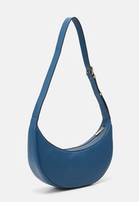 Sac à épaule en cuir bleu au design incurvé, avec une bandoulière réglable et des accents en métal doré ; dispose d'une fermeture à glissière pour plus de sécurité.