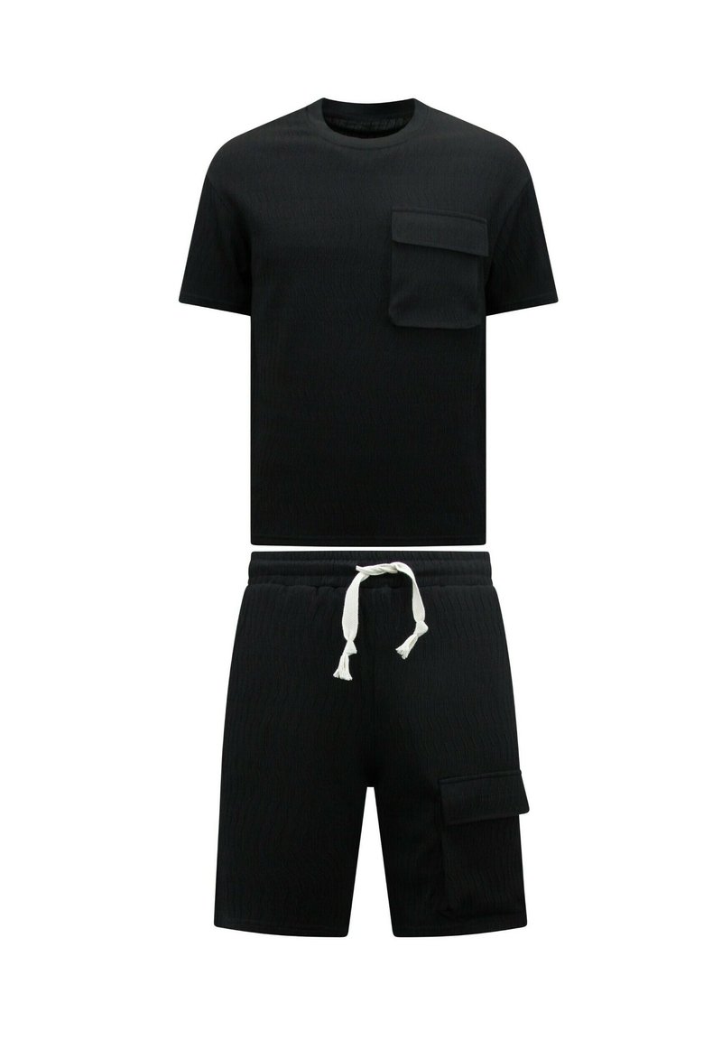 Zwarte gebreide t-shirt met korte mouwen en een borstzakje, gecombineerd met bijpassende zwarte shorts met een zijzak en een witte koord.