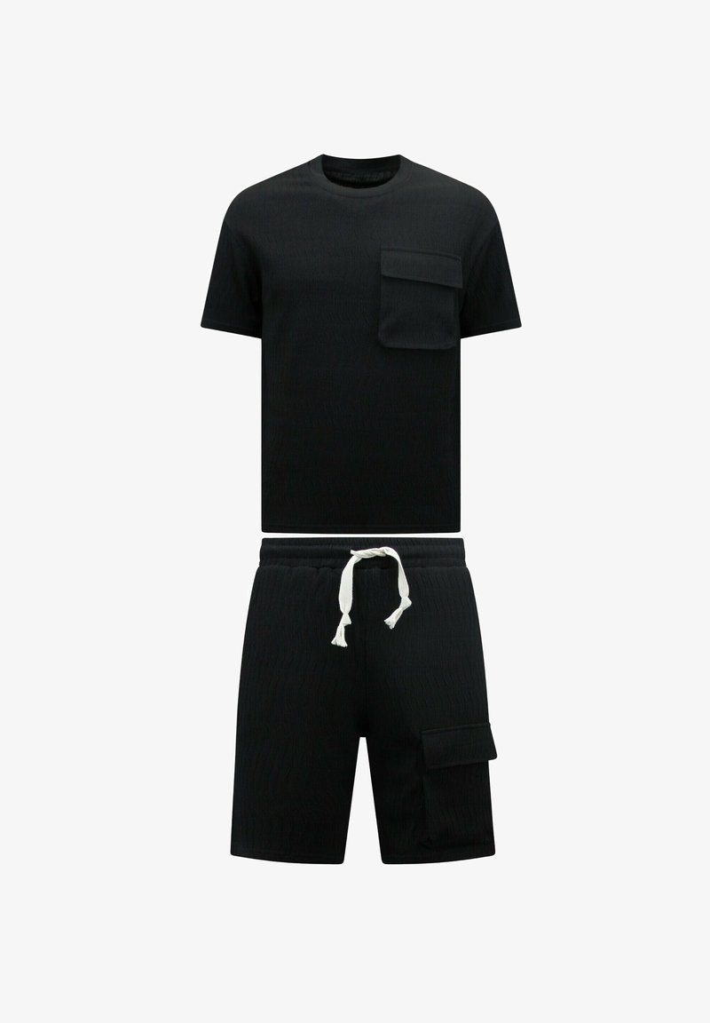 Zwarte gebreide t-shirt met korte mouwen en een borstzakje, gecombineerd met bijpassende zwarte shorts met een zijzak en een witte koord.