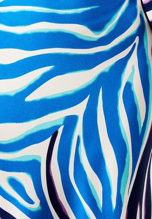 Blue and white fabric features a wavy pattern with varying shades of blue, accented by hints of purple and a textured weave.