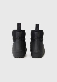 Czarne sneakersy typu high-top wykonane z teksturowanej tkaniny i gumy. Posiadają okrągły czubek, szwy przyszyte oraz elastyczne zapięcie z tylnym uchwytem.