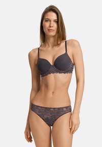 Tmavě šedá podprsenka s vycpávkami a květinovými krajkovými detaily podél spodního okraje, která je doplněna odpovídajícími krajkovými bikinovými kalhotkami. Oba kousky mají hladkou texturu.