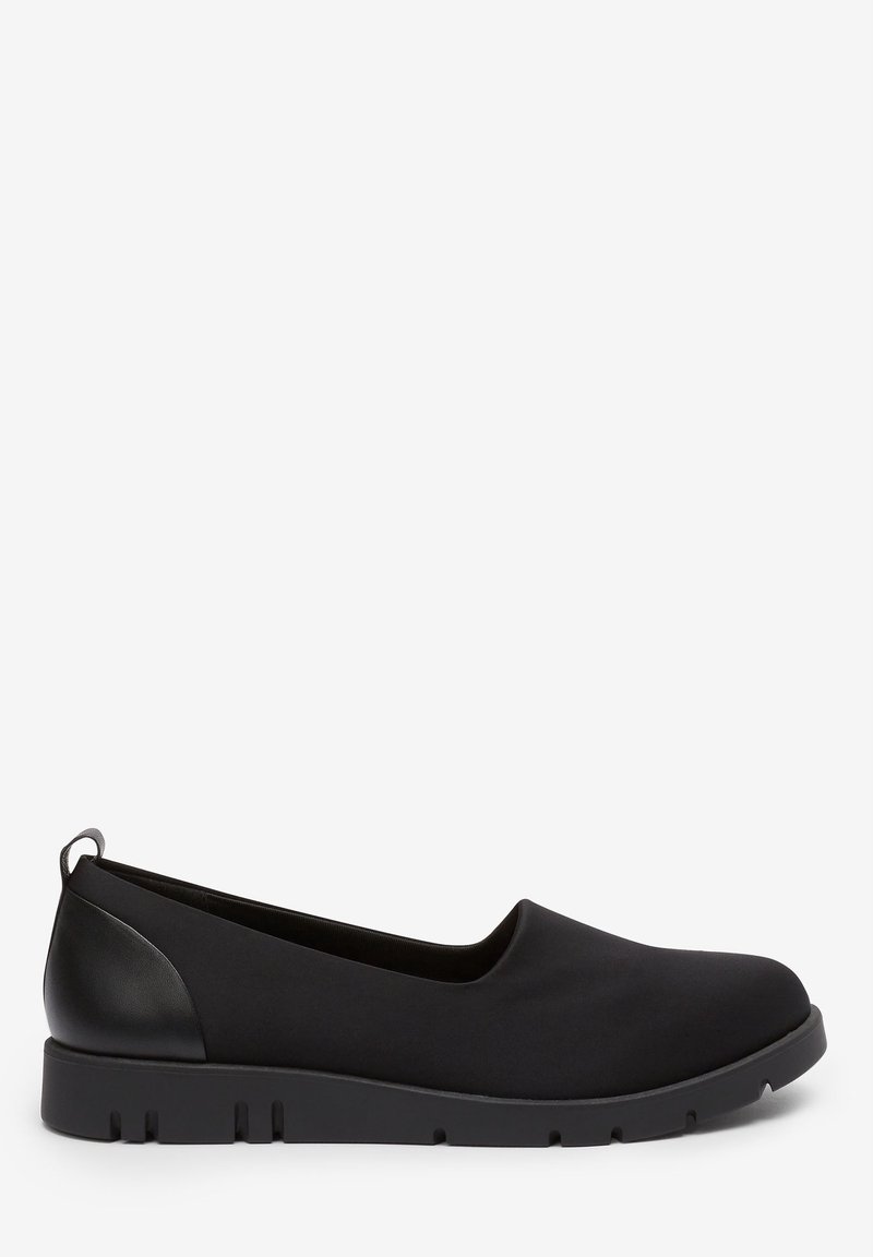 Chaussure plate noire sans lacets, à bout arrondi, semelle texturée et languette en cuir au talon, vue de côté sur fond blanc.