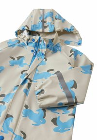 Αδιάβροχο αδιάβροχο μπουφάν σε ανοιχτό μπεζ χρώμα με μοτίβα αλόγων σε μπλε και γκρι. Διαθέτει κουκούλα, κλείσιμο με φερμουάρ και ελαστικές μανσέτες.