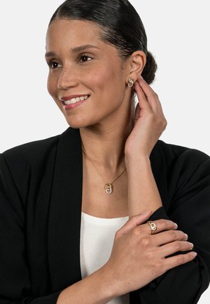 Gold jewelry set featuring a pendant necklace with a glittering accent, matching hoop earrings, and a ring with a similar design.