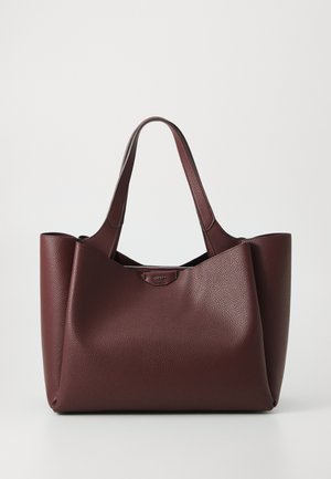Bordowa skórzana torba typu tote o wyraźnym kształcie, teksturowanej powierzchni i podwójnych uchwytach. Posiada metaliczny logotyp na przodzie.