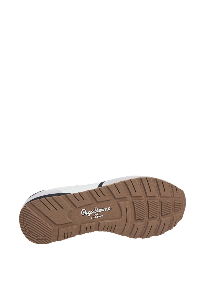 Zapatilla con una suela exterior de goma beige, parte superior blanca y acentos negros. Cuenta con una banda de rodadura texturizada para mayor agarre y un logotipo en el costado.