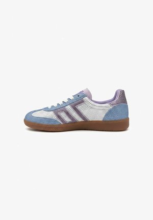 Sneaker low-top con pannelli glitterati bianchi, blu e viola, lacci bianchi e suola in gomma marrone, mostrata di profilo su sfondo bianco.