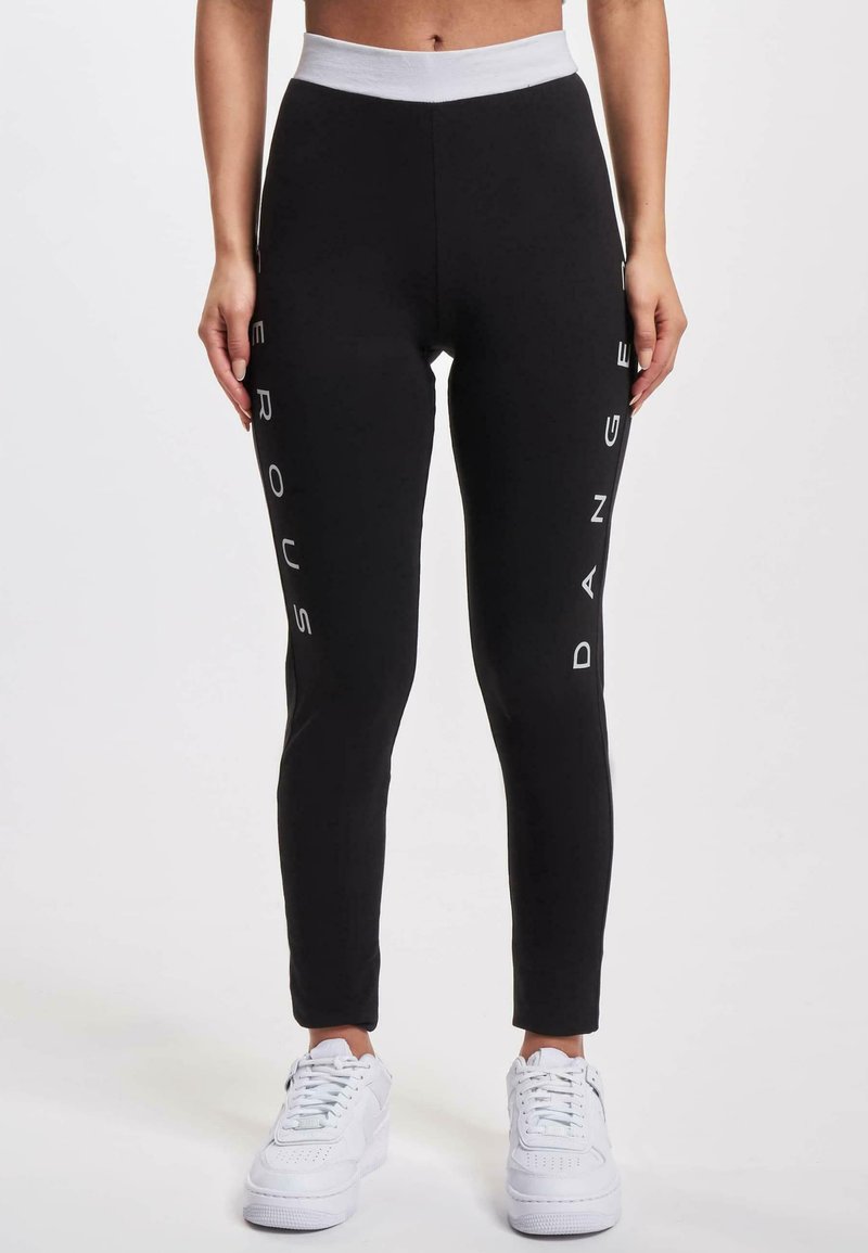 Black leggings with a white elastic waistband, featuring the words “DANGEROUS” and “SERIOUS” printed vertically in white on the sides.