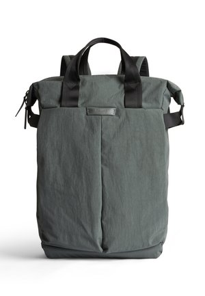 Sac à dos gris foncé avec un tissu texturé et résistant à l'eau, doubles poignées supérieures et bretelles réglables. Comprend une fermeture éclair et un détail de logo.