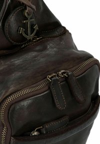 Borsa in pelle marrone con finitura testurizzata, dotata di accessori in bronzo, cerniere e un accento a forma di ancora. Include vari scomparti con cerniera.