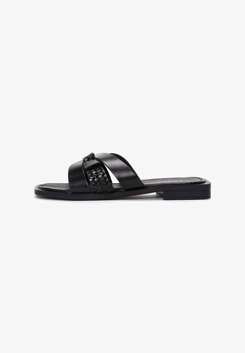 Black slide sandal featuring a woven strap design with smooth leather accents. Flat sole with a slight heel, minimalist shape, and clean lines.