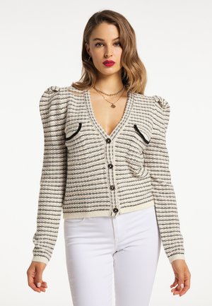 Lichtgewicht gebreide cardigan in crème met zwarte strepen. Heeft poffende mouwen, twee opgestikte zakken en zwarte knopen.