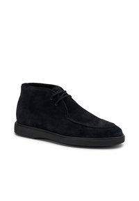 Botines de ante negros con un diseño limpio, punta redondeada y cierre de cordones. Presentan una parte superior texturizada y una suela negra lisa.