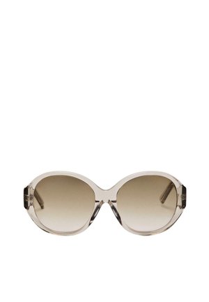 Lunettes de soleil surdimensionnées à monture beige transparente et verres bruns dégradés, centrées sur un fond blanc.