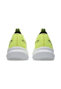 Bright yellow athletic shoes with textured fabric, black accents, and a white sole. Features a pull tab and reflective details at the heel.