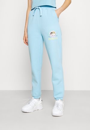 Lichtblauwe sweatpants van zacht materiaal, met een elastische tailleband met trekkoord en een aansluitende enkel. Inclusief een pastel grafisch ontwerp.