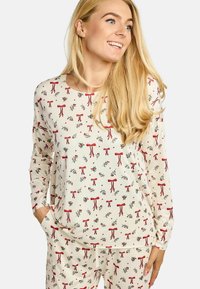 Kreminas ar garām piedurknēm pidžamas krekls ar ziedu rakstu, kas rotāts ar sarkaniem lentēm un zaļām lapām. Mīksts audums ar brīvu piegriezumu.