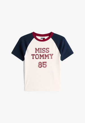 Bavlněné tričko s raglánovými námořnickými rukávy. Na krémovém pozadí červený třpytivý nápis "MISS TOMMY 85". Kruhový výstřih.